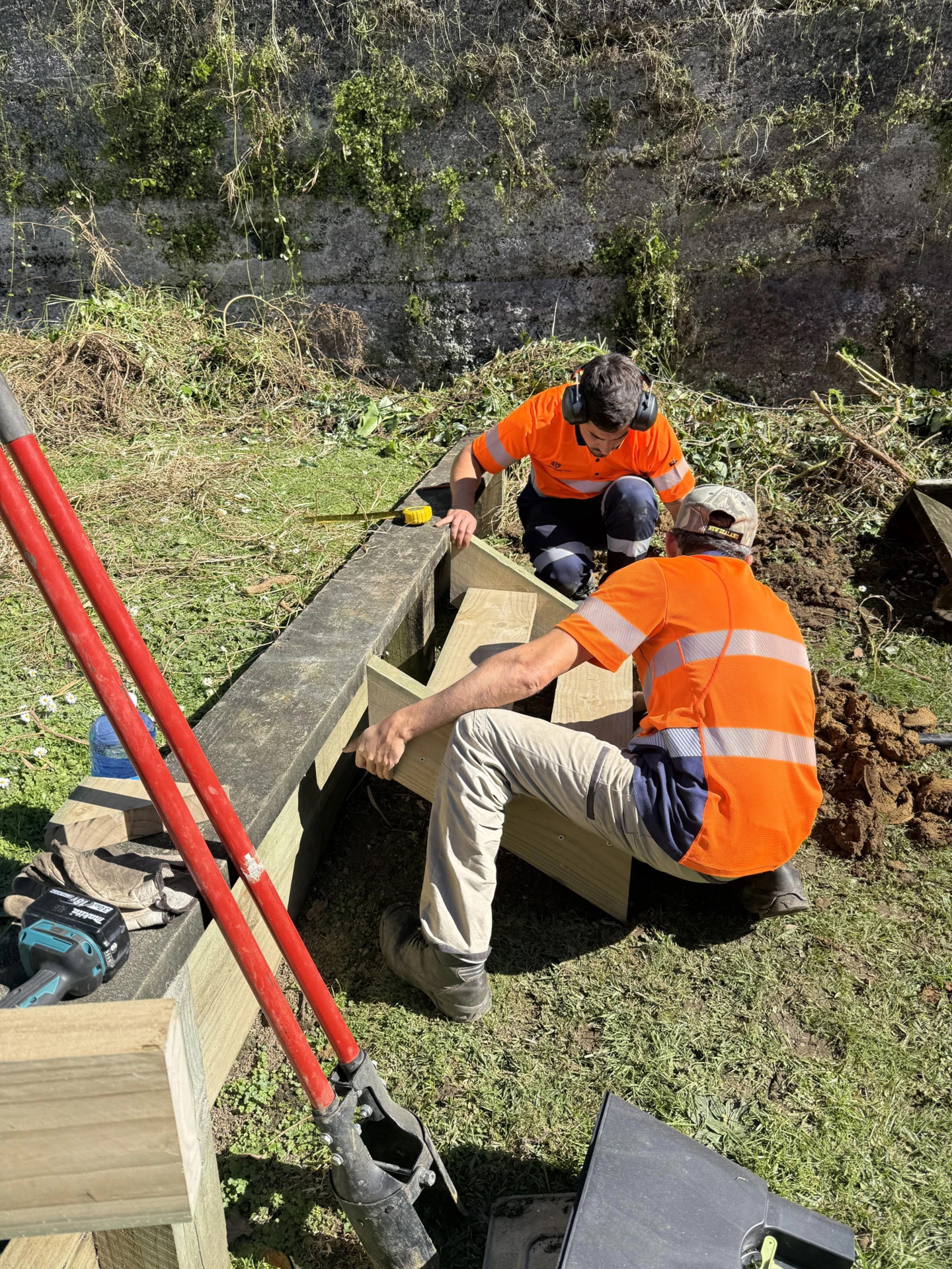 Two Masterscape crew members constructing timber garden steps during a landscaping project in Auckland