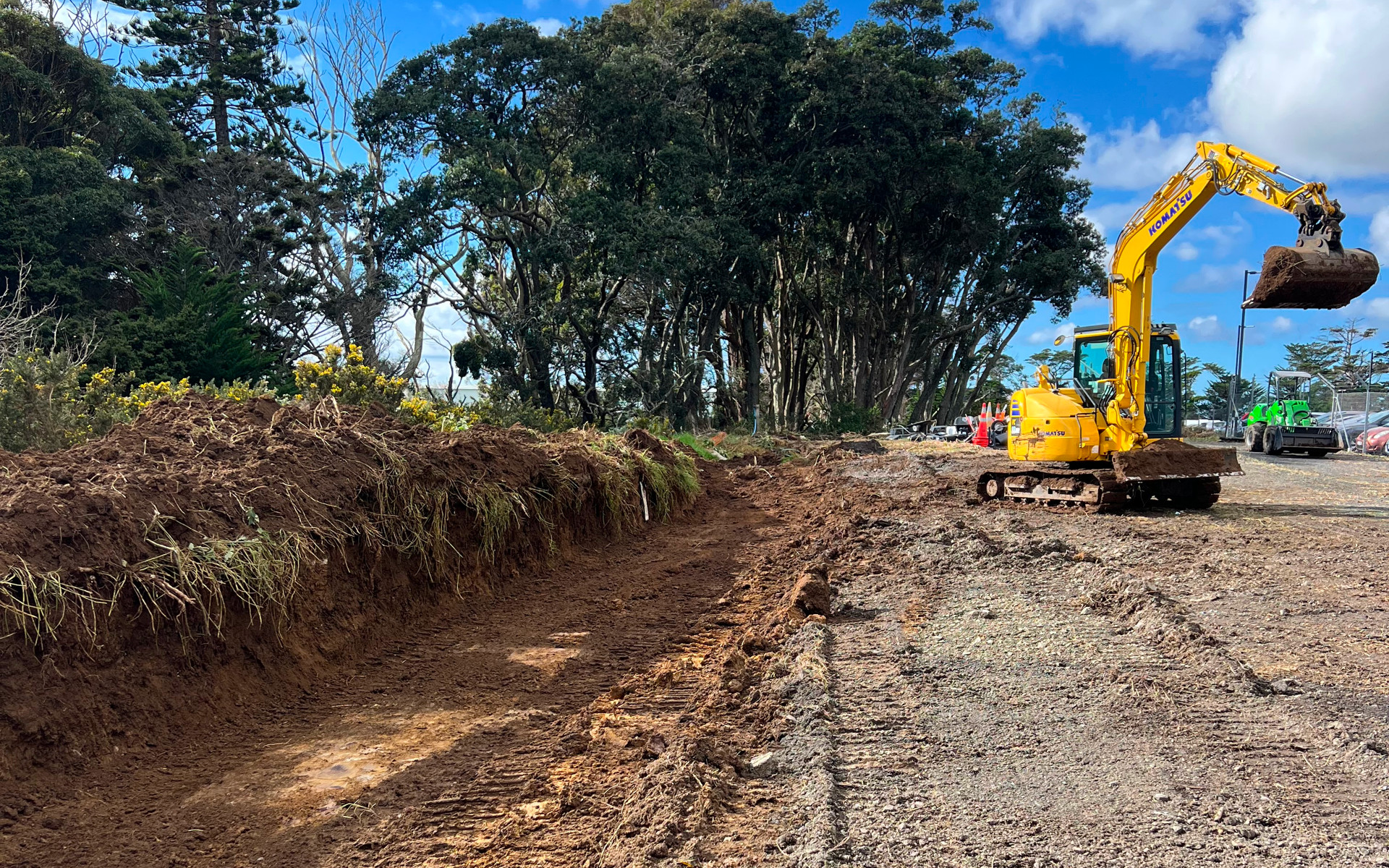 Komatsu excavator carrying out land clearing and vegetation removal on a large commercial site in Auckland